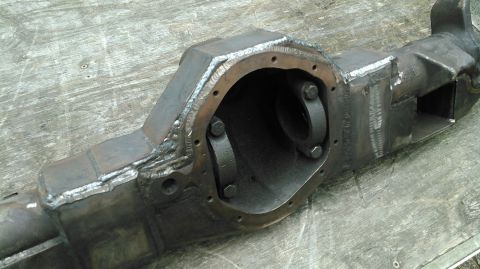 1978 Ford Bronco - A heavily modified, welded differential housing sits on a weathered wooden surface. The housing appears to be made of steel and shows signi…