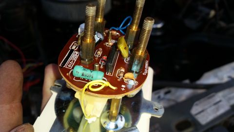1985 Ford Bronco - A close-up view of a circuit board with several brass studs protruding from it. Text on the board reads "M-ASSY-219" and "750602-073G".