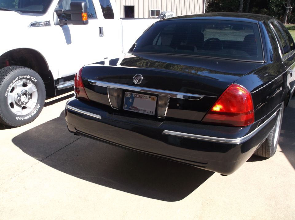 Black 2001 Mercury Grand Marquis rear driver's side, parked next to a white pickup truck.