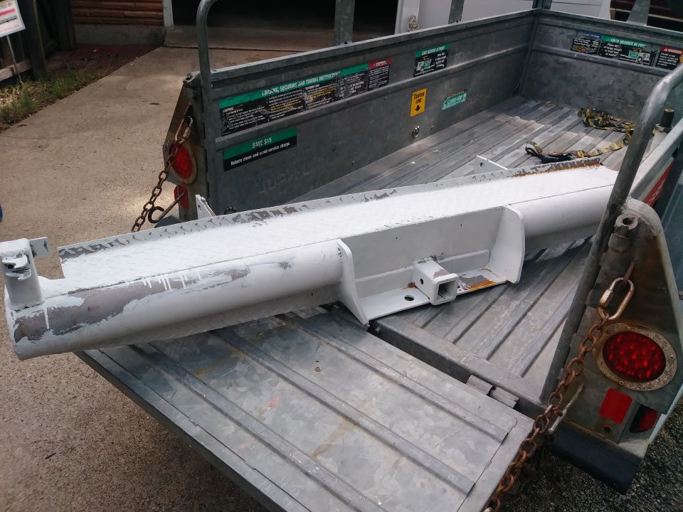Trailer hitch receiver on a metal trailer with a red taillight.