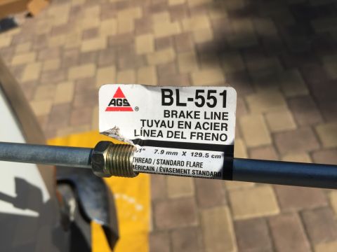 1978 Ford Bronco - A close-up of a label on a metal brake line reads "BL-551 BRAKE LINE TUYAU EN ACIER LÍNEA DEL FRENO". The label also indicates "THREAD / ST…