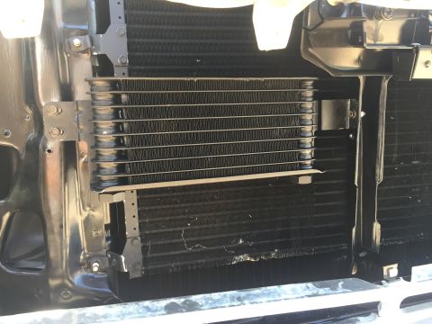 1978 Ford Bronco - This image shows the front of a vehicle's engine bay, focusing on the transmission cooler and radiator. The transmission cooler is mounted…