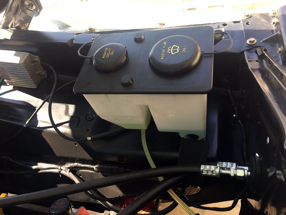 Engine bay with washer fluid and coolant reservoirs