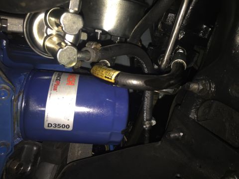 1978 Ford Bronco - A close-up view of a blue Bosch D3500 oil filter and associated fuel lines attached to an engine component.