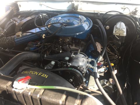 1978 Ford Bronco - A close-up view of the engine bay of a classic Ford Bronco, showcasing the air intake, engine components, and radiator.