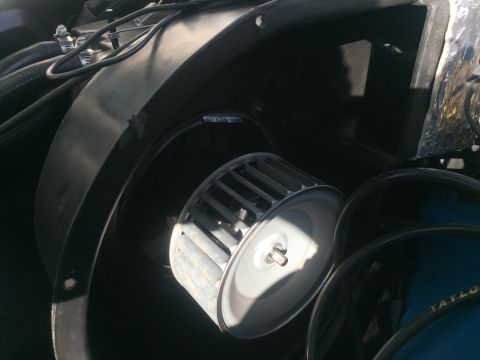 1978 Ford Bronco - A close-up view of a vehicle's blower motor and fan assembly, showing the squirrel cage fan inside a black housing. Text on the housing rea…