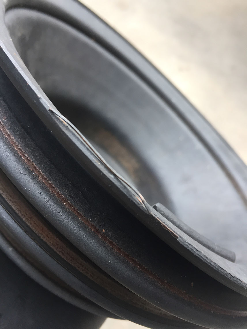 Close-up of a torn speaker surround with rust marks