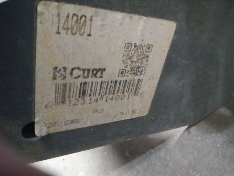 1996 Ford Bronco - A close-up view of a white label with black text and a QR code, attached to a dark-colored vehicle part. The label displays the number "140…
