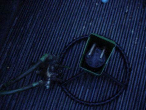 1992 Ford Bronco - A close-up view of an electrical connector and a hose, likely a part from a vehicle or equipment.