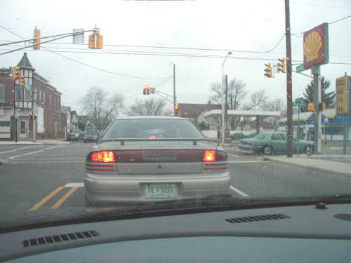 Silver sedan with a spoiler, rear view, license plate 1B 5093, in traffic