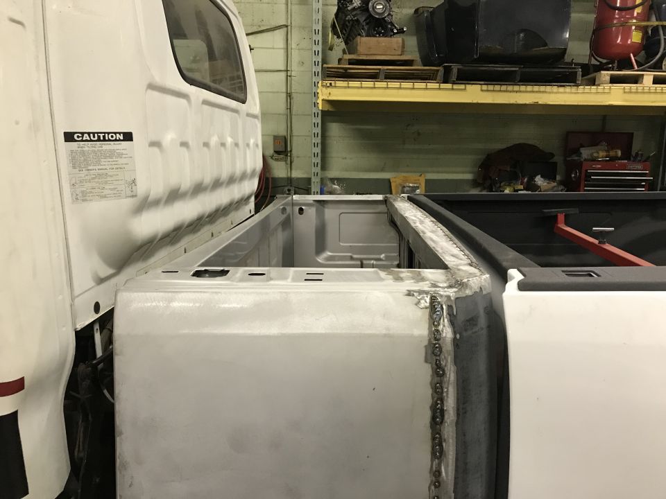 White pickup truck bed with custom metal work and welding.