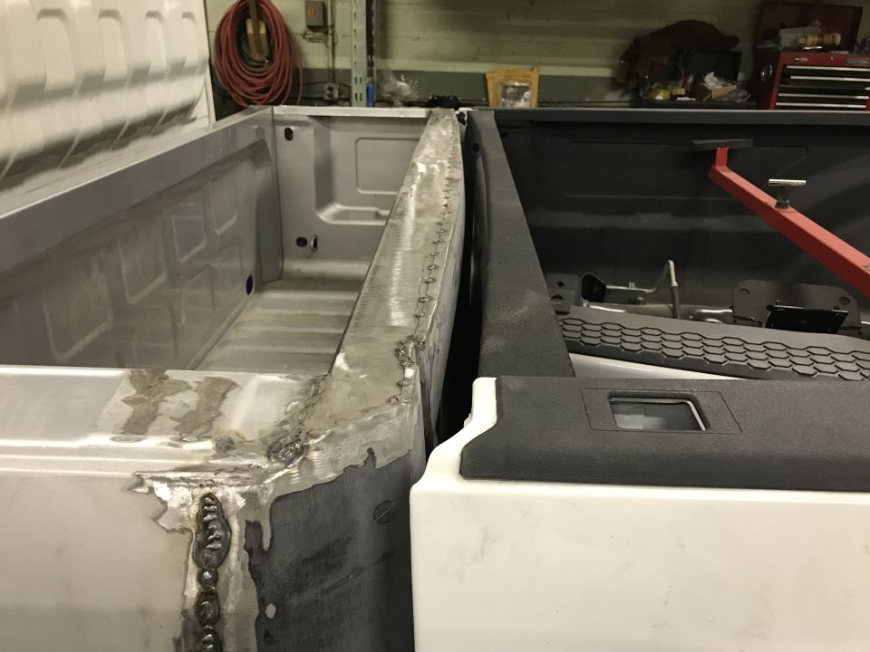 Close-up of a pickup truck bed with custom metalwork and welding.