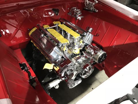 1964 Ford Fairlane - A highly polished V8 engine with chrome components and yellow tape on the valve covers is installed in the engine bay of a red vehicle.