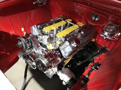 1964 Ford Fairlane - A highly polished chrome V8 engine is installed in the engine bay of a red vehicle. The engine features Ford Racing valve covers and is sur…