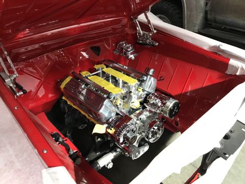 1964 Ford Fairlane - A highly polished Ford Racing engine is installed in the engine bay of a red classic car, likely a 1964 Ford Fairlane, as indicated by the…