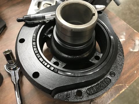 1964 Ford Fairlane - A black cast iron crankshaft pulley with a metal sleeve is shown on a wooden surface. A silver socket wrench and a black pen are also visib…