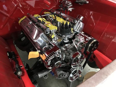 1964 Ford Fairlane - A highly polished chrome Ford Racing engine is installed in the engine bay of a red vehicle. The engine features a distributor, alternator,…