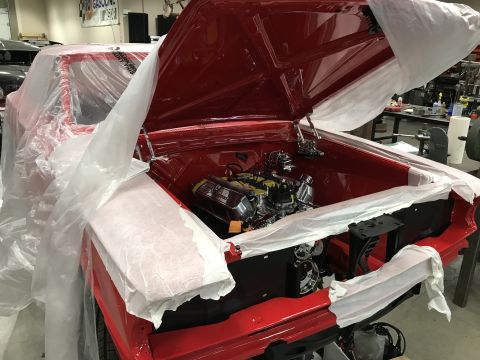 1964 Ford Fairlane - A red 1964 Ford Fairlane is partially covered in protective plastic in a workshop. The hood is open, revealing a chrome engine and other co…