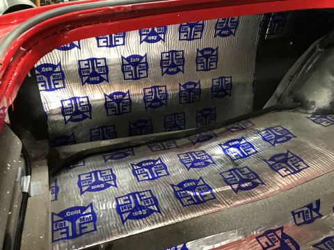 1964 Ford Fairlane - The interior of a vehicle's trunk area shows sound deadening material with a repeating blue and silver logo pattern. A black rubber seal ru…