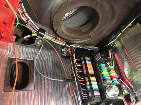 1964 Ford Fairlane - A close-up view of a custom wiring harness and fuse block installation in a vehicle. The harness features numerous color-coded wires neatly…