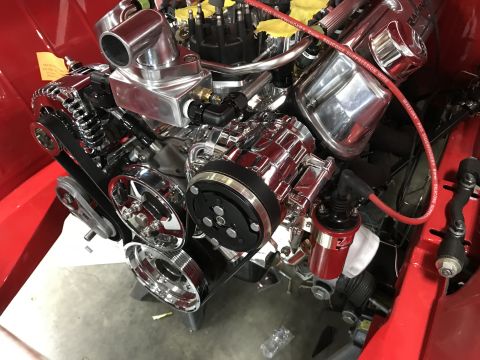 1964 Ford Fairlane - A highly polished chrome engine assembly is installed in a red vehicle. The engine features a serpentine belt system, a chrome air conditio…