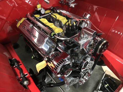 1964 Ford Fairlane - A polished Ford Racing V8 engine is installed in a red vehicle's engine bay. The engine features chrome valve covers with "Ford Racing" tex…