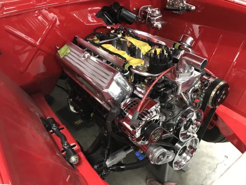 1964 Ford Fairlane - A highly polished chrome engine is installed in a bright red engine bay. The engine features a V8 configuration with custom valve covers an…