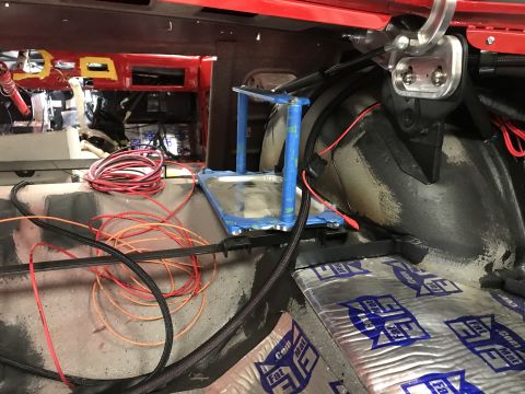 1964 Ford Fairlane - The interior of a vehicle undergoing modification, showing various wires, sound-dampening material on the floor, and a red dashboard area w…