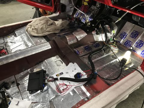 1964 Ford Fairlane - The interior of a classic car, likely a 1964 Ford Fairlane, is shown with the floor covered in sound deadening material and various wiring…