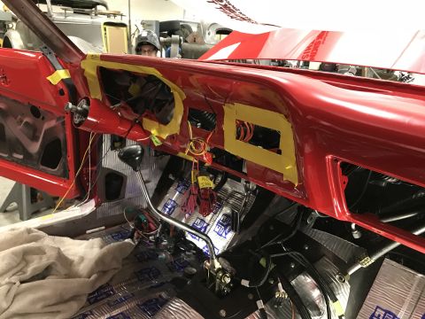 1964 Ford Fairlane - The interior of a red 1964 Ford Fairlane is shown during a restoration or modification process. The dashboard is partially disassembled wit…