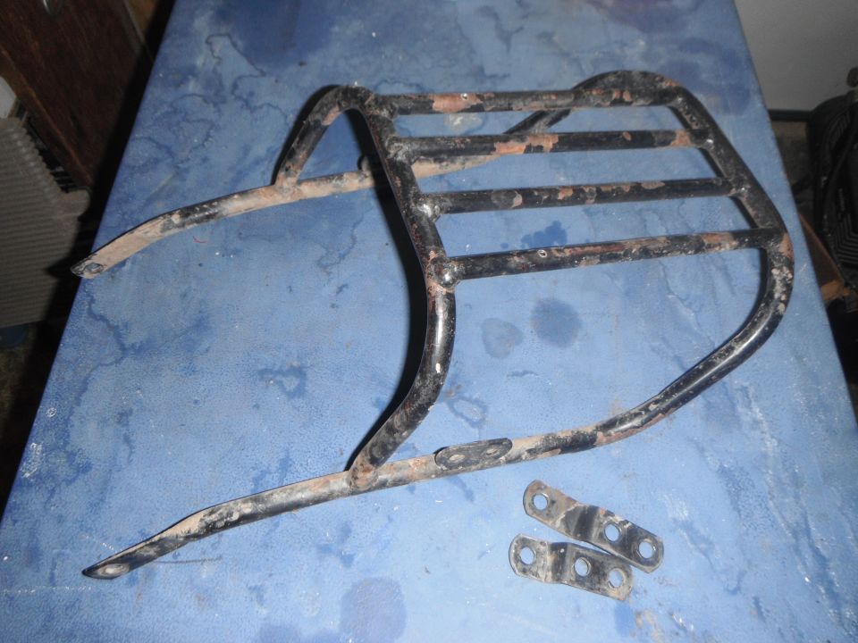Rusty black metal motorcycle luggage rack with two mounting brackets