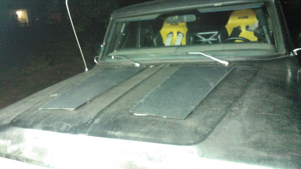 1978 Ford Bronco hood with two dark panels and racing seats visible through the windshield