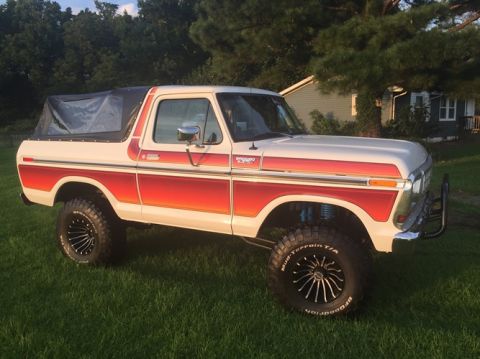 1979 Ford Bronco - This lifted Ford Bronco features a two-tone paint scheme with orange and red stripes.