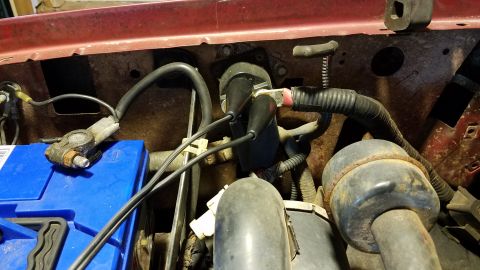 1994 Ford Bronco - Close-up view of a vehicle's engine bay, focusing on the battery and wiring harness.