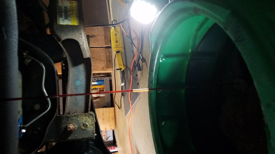 Green fender and suspension components with a yellow work light