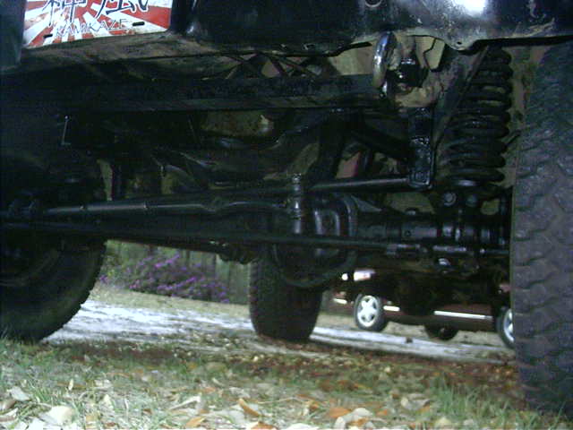 Underside view of a lifted 4x4 front coil-spring suspension, radius arms and front differential