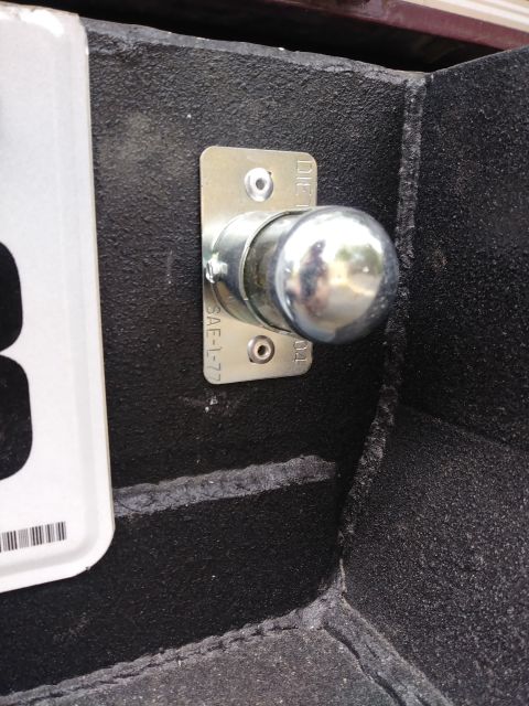 1996 Ford Bronco - A close-up view of a trailer hitch ball mount attached to a black textured surface, likely a truck bed or bumper. Visible text on the mount…