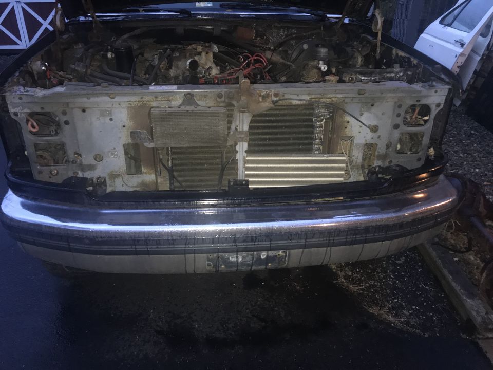 Front view of a disassembled 1992 Ford Bronco engine bay with radiator and chrome bumper.