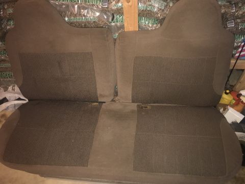 1992 Ford Bronco - A pair of brown fabric car seats, likely from a truck or SUV, are shown in a storage area. The seats have a textured insert panel on both t…