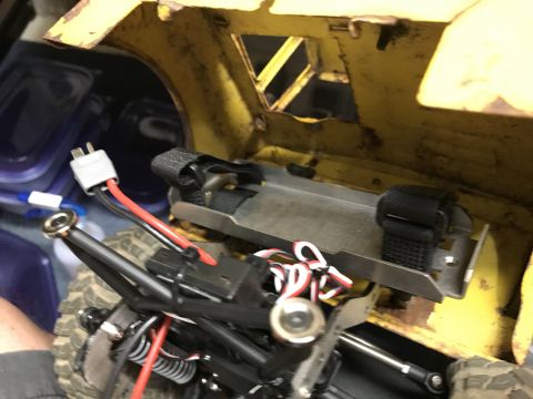 1989 Ford Bronco - A close-up view of the interior of a yellow RC vehicle, showing wiring, a battery connector, and part of the chassis.