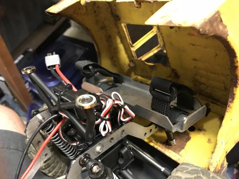 1989 Ford Bronco - Close-up view of the interior of a vehicle, showing wiring, a battery connector, and a metal bracket with a black velcro strap. The vehicle…