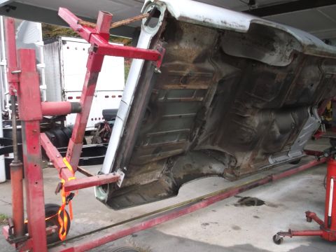 1962 Ford Galaxie - Car's undercarriage is visible while it's raised on jack stands for maintenance.