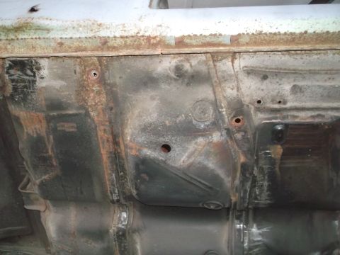 1962 Ford Galaxie - Undercarriage view reveals significant rust on the frame and floor pan components.