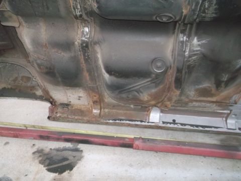 1962 Ford Galaxie - The undercarriage of a vehicle displays significant rust and evidence of recent repairs to the frame.