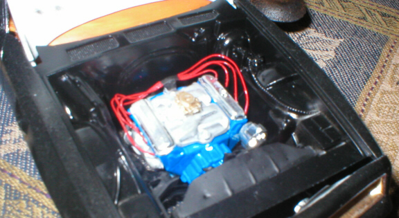 Model car engine bay with chrome block, blue base and red plug wires