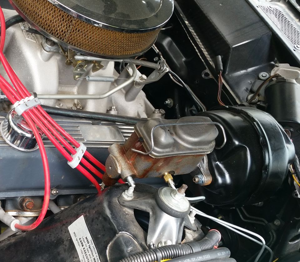 Engine bay with chrome air cleaner, red spark plug wires, and brake master cylinder.