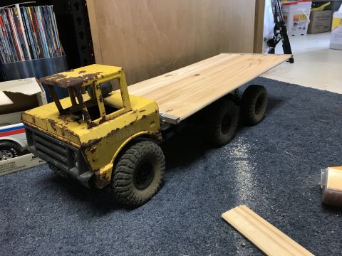 1989 Ford Bronco - A weathered, yellow Tonka toy truck with a flatbed trailer sits on a blue carpet. The truck is heavily rusted, and the trailer is made of u…