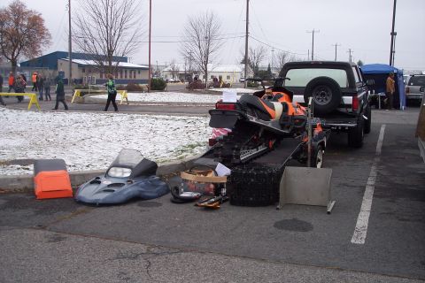 1995 Ford Bronco - A black Ford Bronco is parked, towing a trailer with a snowmobile and other items, with people in the background.