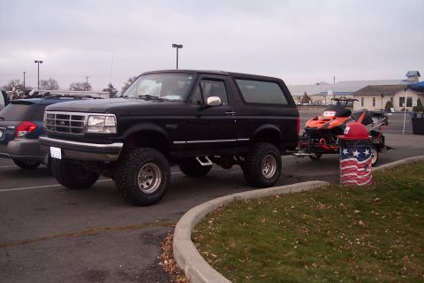 1995 Ford Bronco - Black 1995 Ford Bronco is parked and towing a snowmobile trailer.