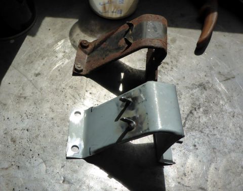 1962 MG B - A comparison of a rusty metal bracket and a freshly painted one is shown on a workbench.